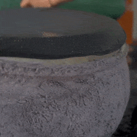 Personne ajustant le coussin d'un lit pour animaux Comfy Wopiloo en peluche grise.